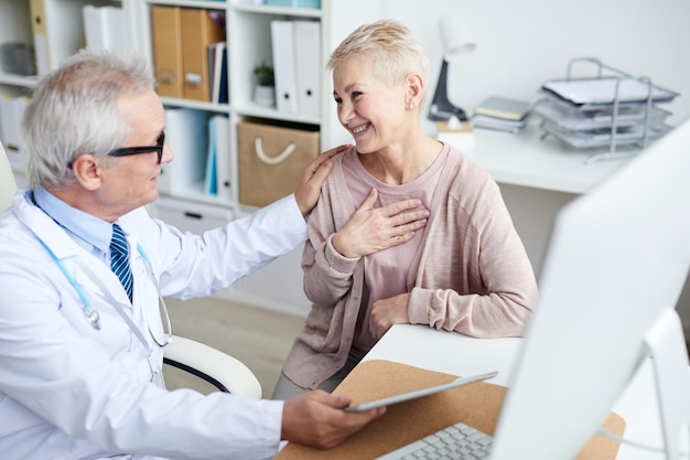 Happy senior patient thanking doctor