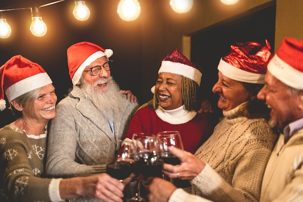 Photo happy senior people celebrating christmas time drinking wine together