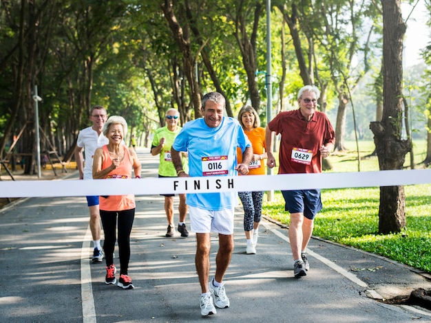 Photo happy senior running through the finish line