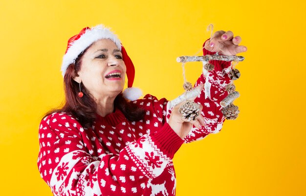 幸せな年配の女性のクリスマスの装飾黄色の背景