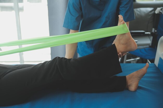 Happy senior woman doing exercise at home with physiotherapist Old retired lady doing stretching arms at home with the help of a personal trainer during a rehabilitation session