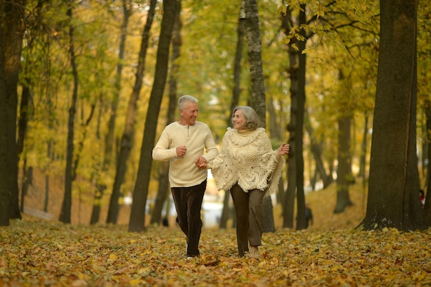 Happy senior woman and man in park running