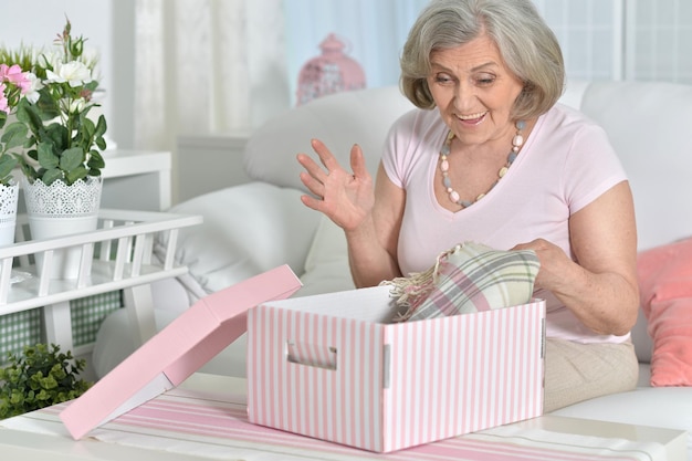 Happy Senior woman portrait on giftbox at home