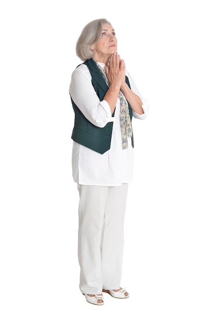 Happy senior woman praying on white background