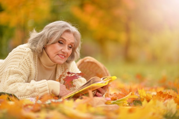 Happy senior woman resting in autumnal park