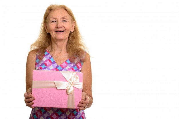 happy senior woman smiling and holding gift box