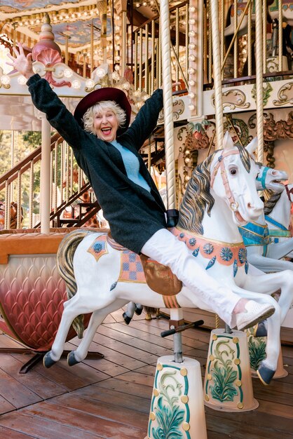 Photo happy senior woman spending nice time at amusement park