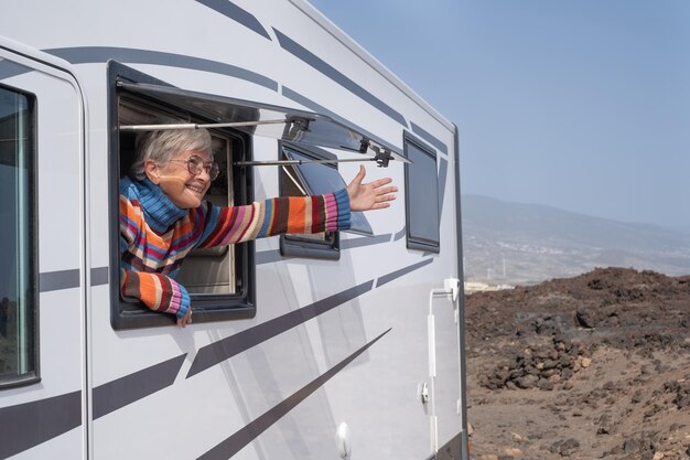 写真 窓の外を眺めながらキャンピングカーに乗って旅行している幸せな高齢の女性