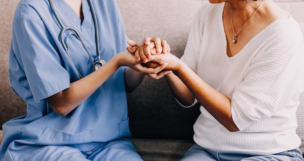 건강 검진 치료 후 낙관적인 소식을 듣는 행복한 고령 여성 의사 방문 치료사는  ⁇ 은 환자의 손을 잡고 희망 지원을 제공하고 치료 결과에 대해 축하합니다.