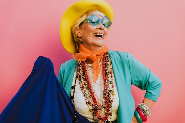 Photo happy senior woman wearing jewelries against pink background