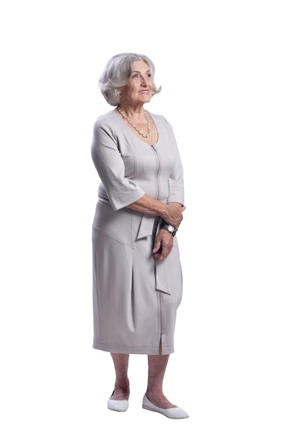Фото Счастливая старшая женщина в светлом платье позирует изолированно на белом фоне