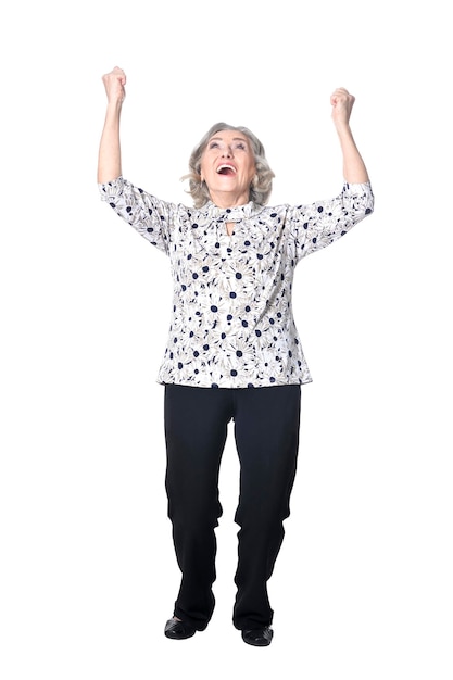 Happy senior woman with hands up on white background