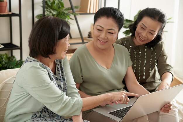 Happy senior women with laptop shopping online together and ordering delivery