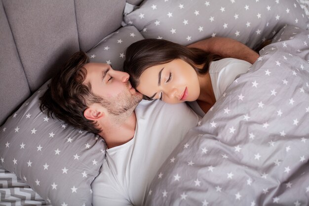 Photo happy sensual young couple lying in bed together.