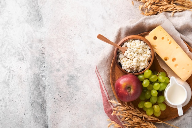 Felice shavuot sfondo per la celebrazione di shavuot latte e formaggio grano maturo e frutta sfondo di legno blu prodotti lattiero-caseari su vecchio tavolo grigio cemento sfondo shavuot concept mock up