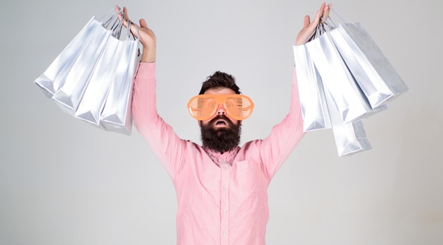 Happy shopping with bunch paper bags. Shopping addicted consumer. How to get ready for your next vacation. Man bearded hipster wear sunglasses while carry lot shopping bags. Shopping on black friday.