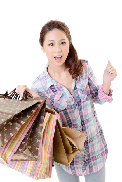 Счастливая женщина покупок азиатских холдинговых сумок