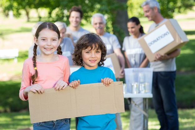 Happy siblings holding blank 