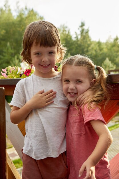 Happy siblings hugging on terrace summer day