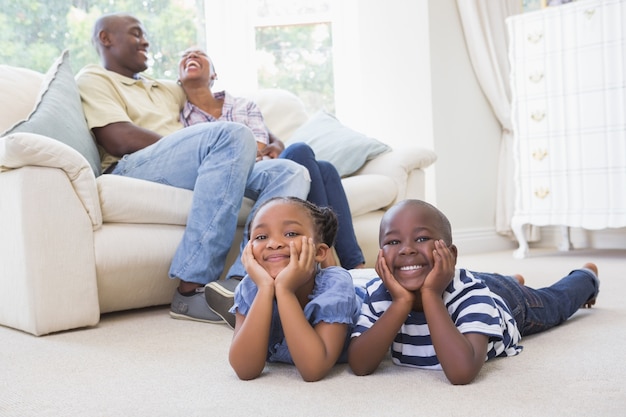 Happy siblings sitting on the floor watching television