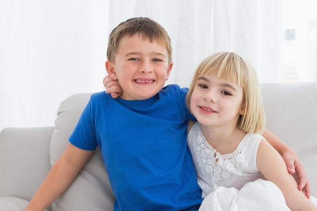 Happy siblings smiling at camera together