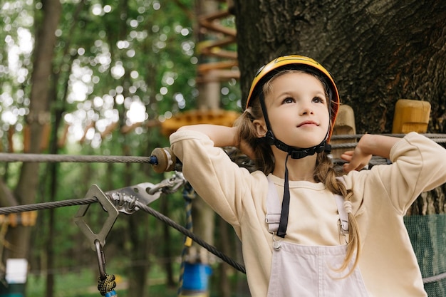 Happy six year girl at climbing activity in high wire forest park