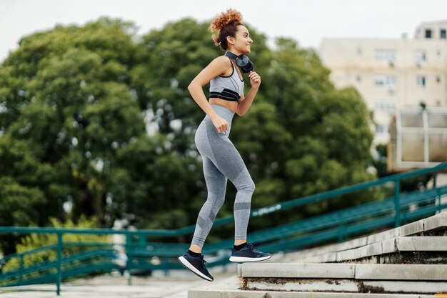 Premium Photo | A happy slim female runner with headphones around her ...