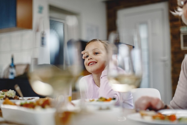 ダイニングルームで昼食をとっている幸せな小さな女の子