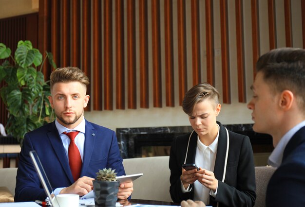 Happy smart business man with team mates discussing in the background