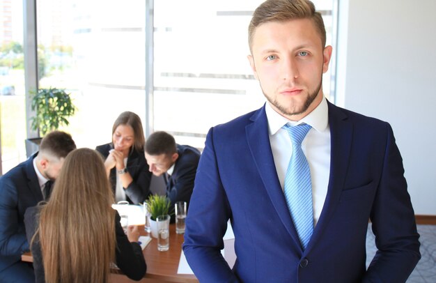 Happy smart business man with team mates discussing in the background