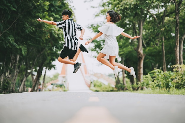 Happy smile Asian lesbian couple jumping off the ground outdoor in the park.