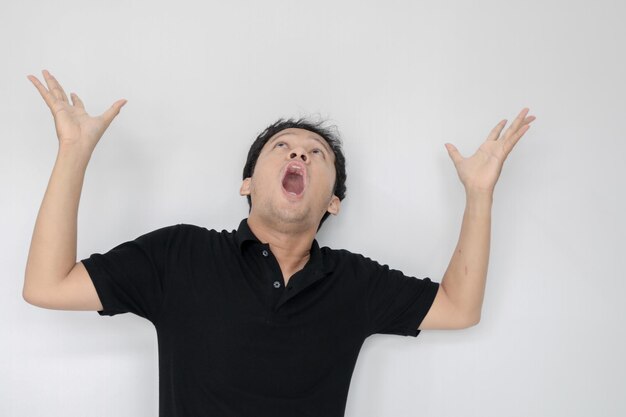 Happy and smile face with smile of young Asian man in black shirt with hand point on above empty space