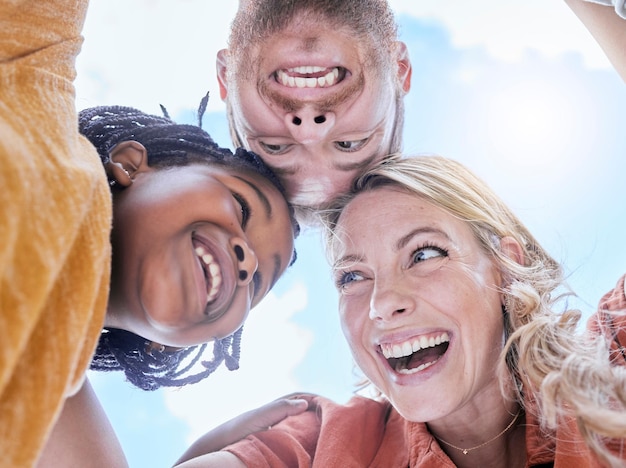 Happy smile and interracial family hug of mother father and girl faces outdoor with love and care Happiness laughing and summer fun huddle of a mom dad and kid with below blue sky view