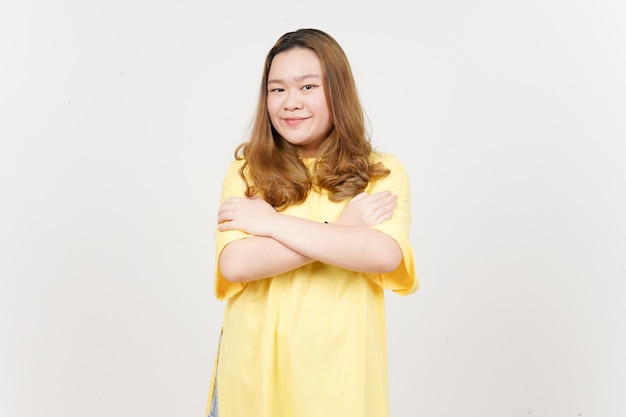 幸せな笑顔と白で隔離された黄色の t シャツを着ている美しいアジアの女性のカメラに探しています。
