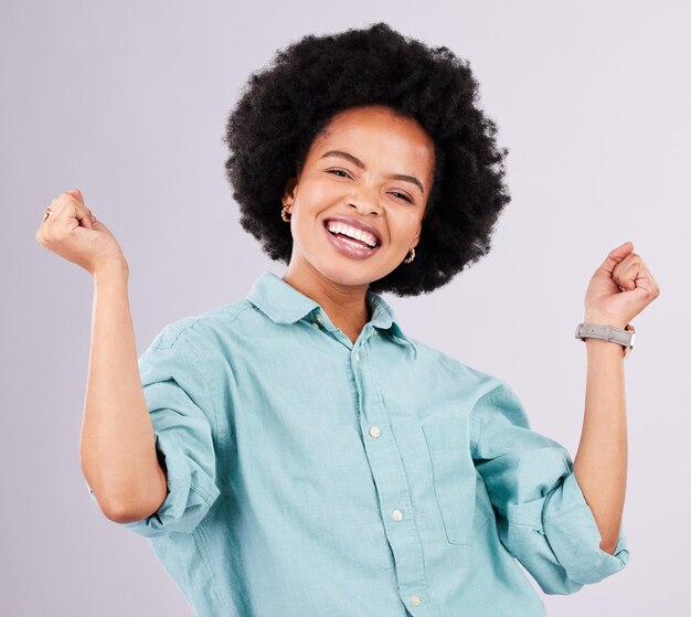 Happy smile and portrait of black woman in studio for celebration surprise and confidence Winner happiness and good news with female isolated on gray background for cheerful yes and excited