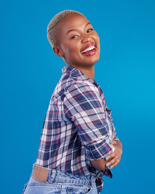 Happy smile and portrait of black woman with confidence happiness and empowerment in studio fashion beauty and girl model laughing on blue background with pride positive mindset and motivation