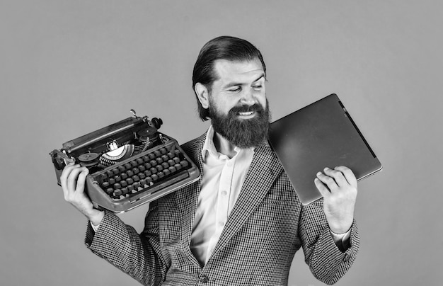 Photo happy smile successful businessman use retro typewriter and computer mature man hold vintage device first draft professional typist make notes typing modern and old technology digital business