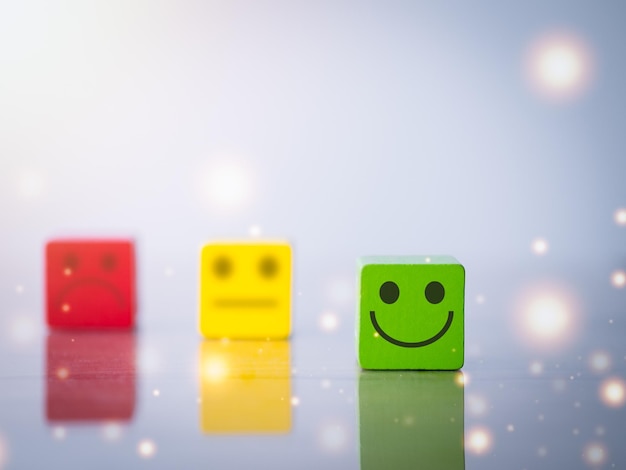 Happy smiley face blurred neutral sad face icon on wood cube\
customer satisfaction survey concept