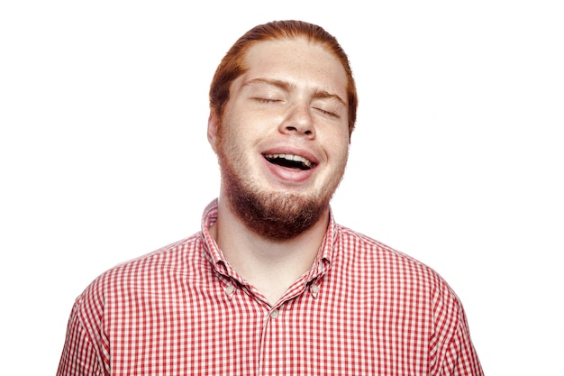 Happy smiley laughing bearded readhead businessman with red shirt and freckles looking at camera. studio shot isolated on white..