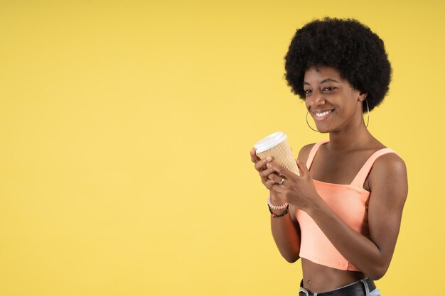 Happy smiling afro woman with a disposable coffee cup