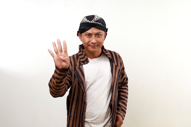 Photo happy smiling asian adult man in javanese costume standing while showing four fingers