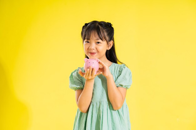 Happy smiling asian girl on yellow background