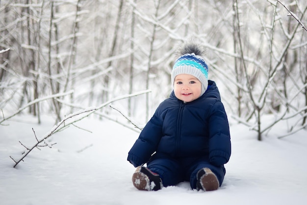 Photo happy smiling baby boy sitting on snow