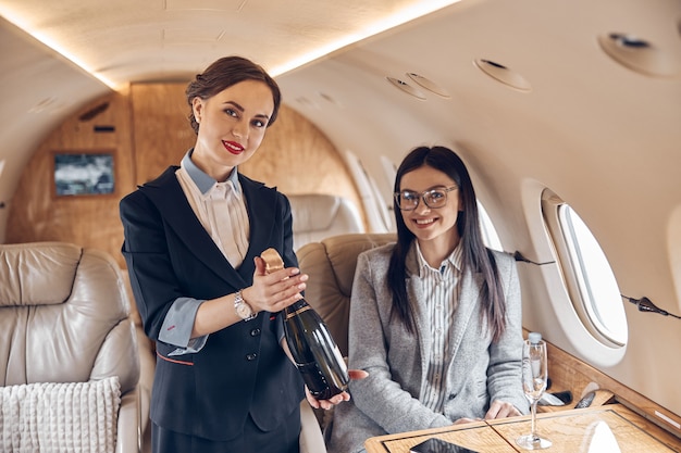 Happy smiling beautiful business woman in private jet