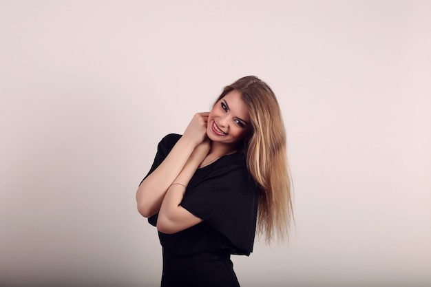 Happy smiling beautiful woman on white wall