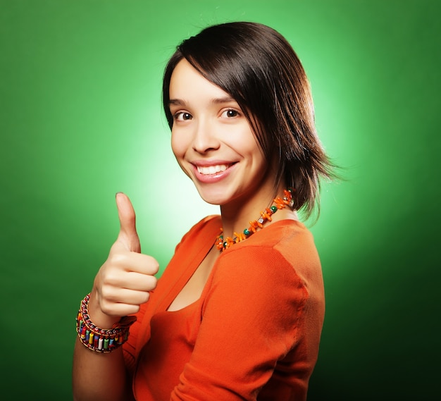 Happy smiling beautiful young woman showing thumbs up gesture