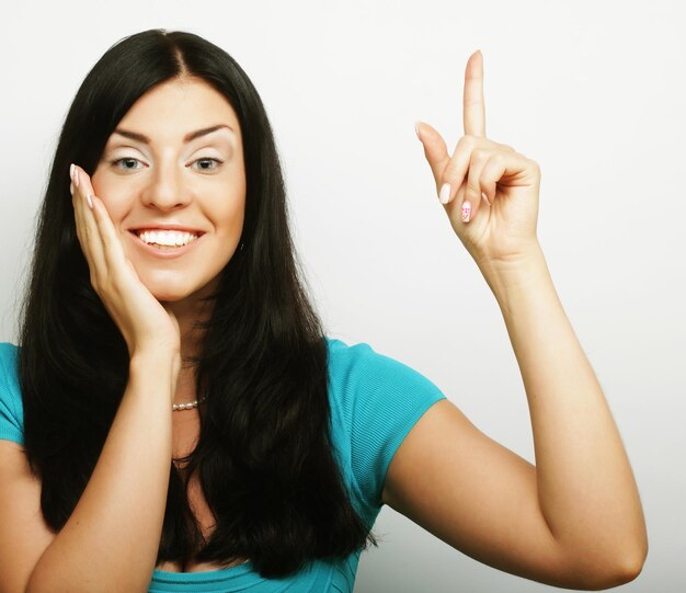 Счастливая улыбающаяся красивая молодая женщина показывает жест "большой палец вверх"