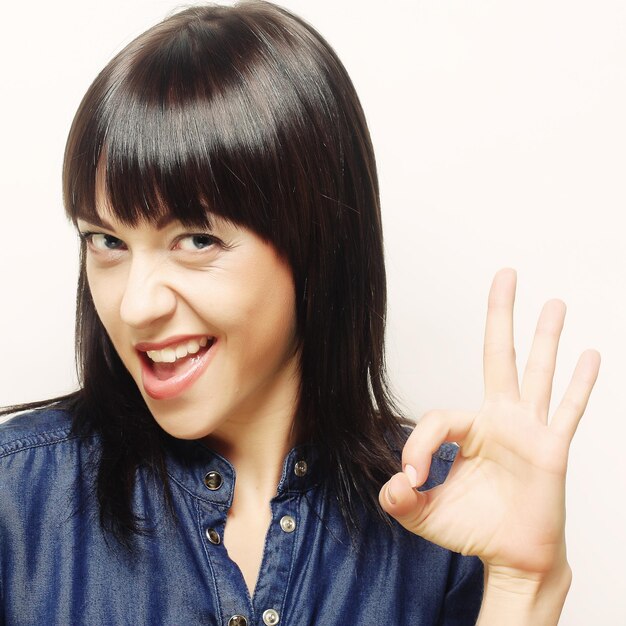 Happy smiling beautiful young woman showing two fingers or victory gesture