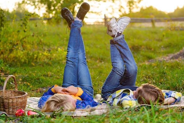 Photo happy smiling boy and girl lying together on the grass