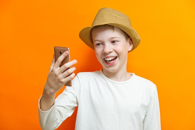 Happy smiling boy holding a smartphone